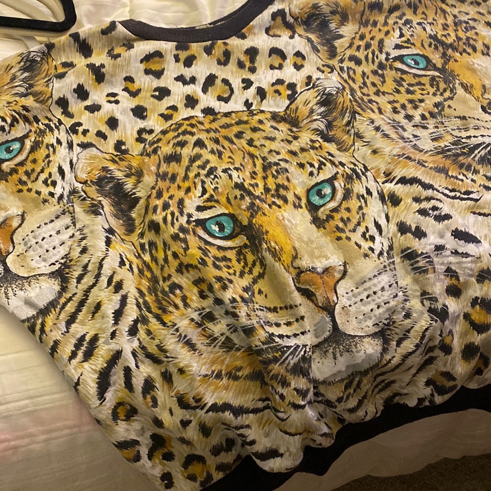 Lion cats with green eyes cheetah print on brand. Short jacket comes to tummy